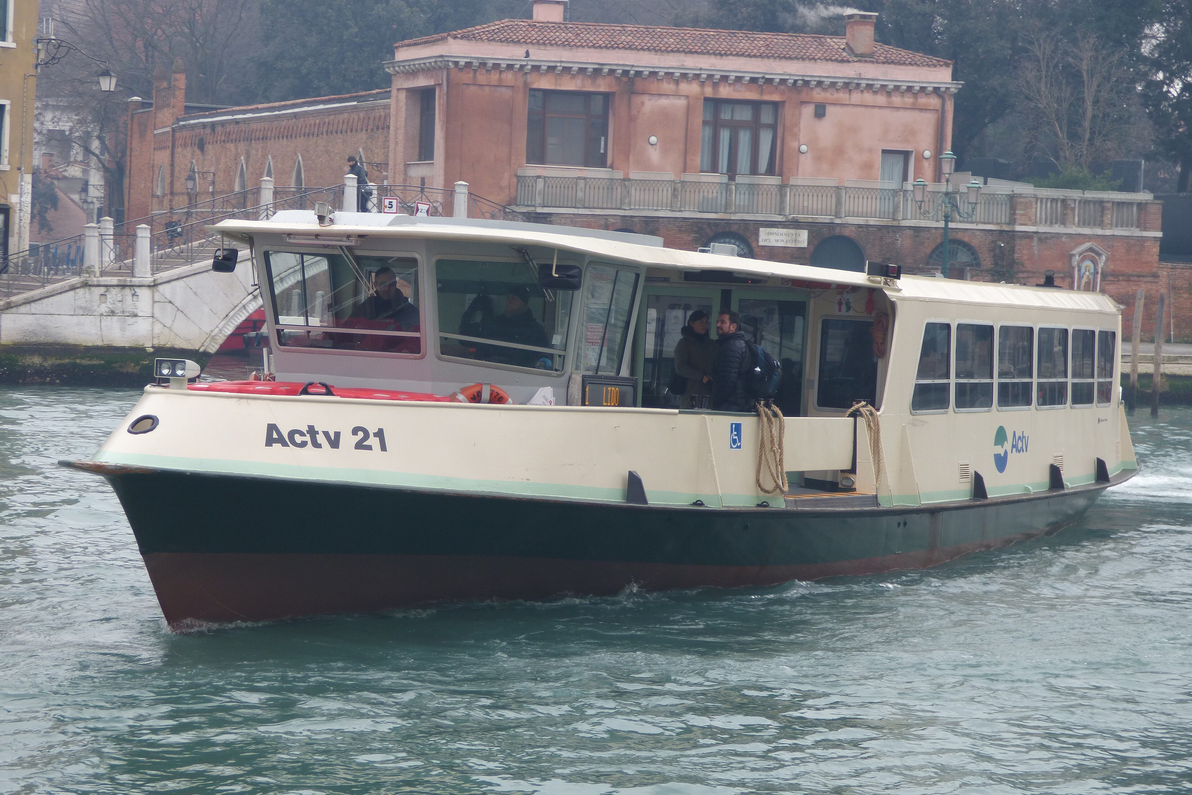 An ACTV vaporetto water bus moving along the Grand Canal past venetian palaces